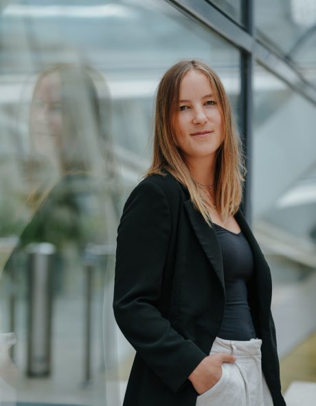 Frau angelehnt an einer Scheibe. In einem Business Outfit.