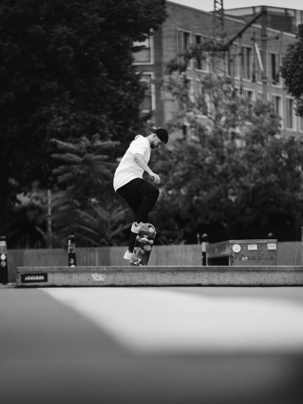 Ein Mann steht auf seinem Skateboard und hat dabei Freude.